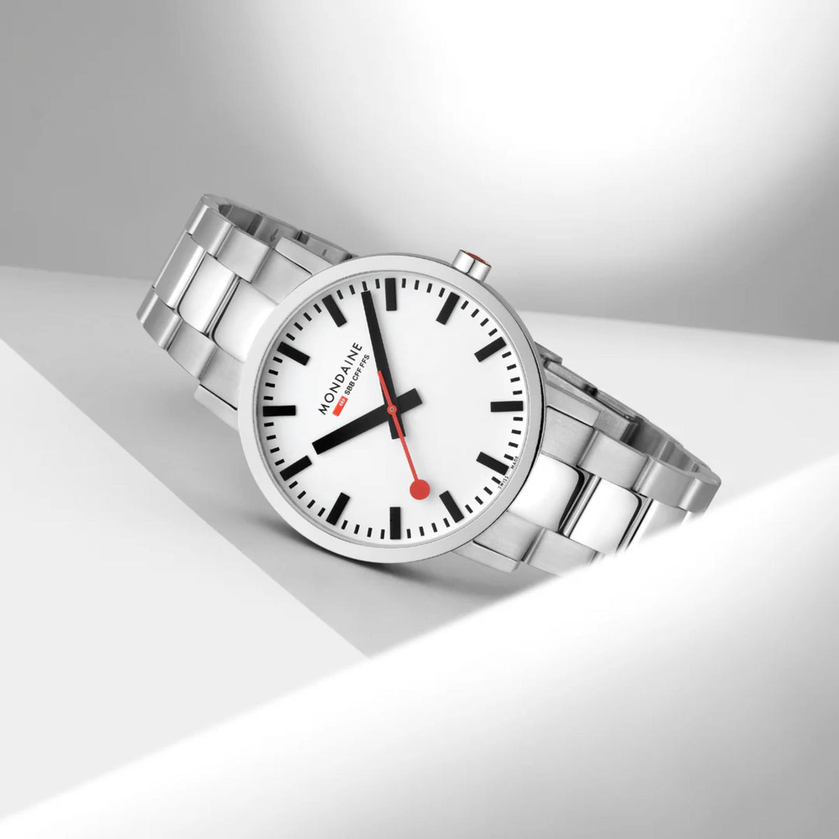 Round steel wristwatch with white dial, black markers, and red hands, angled view