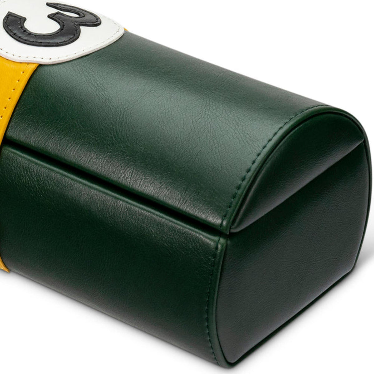 Corner view of green watch case pouch with yellow edge trim and stitched white emblem patch