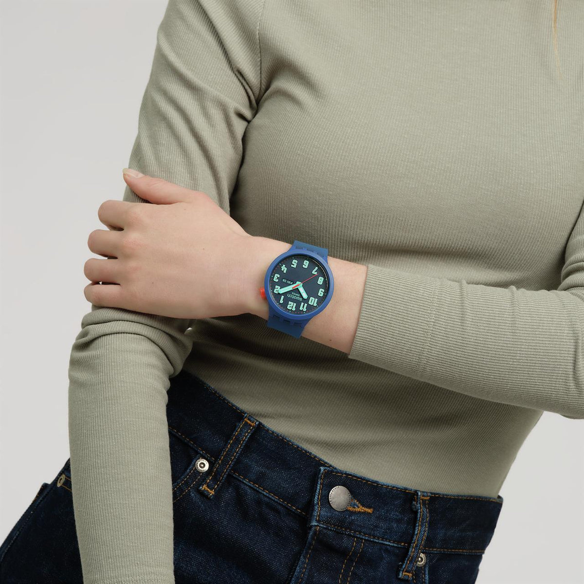 Swatch blue silicone strap watch on wrist, dark blue dial with bold numerals
