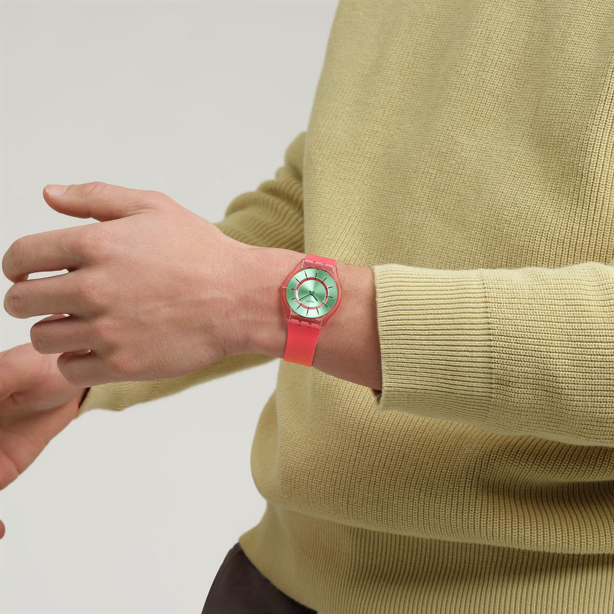 Red silicone wristwatch with mint dial and translucent band on a wrist