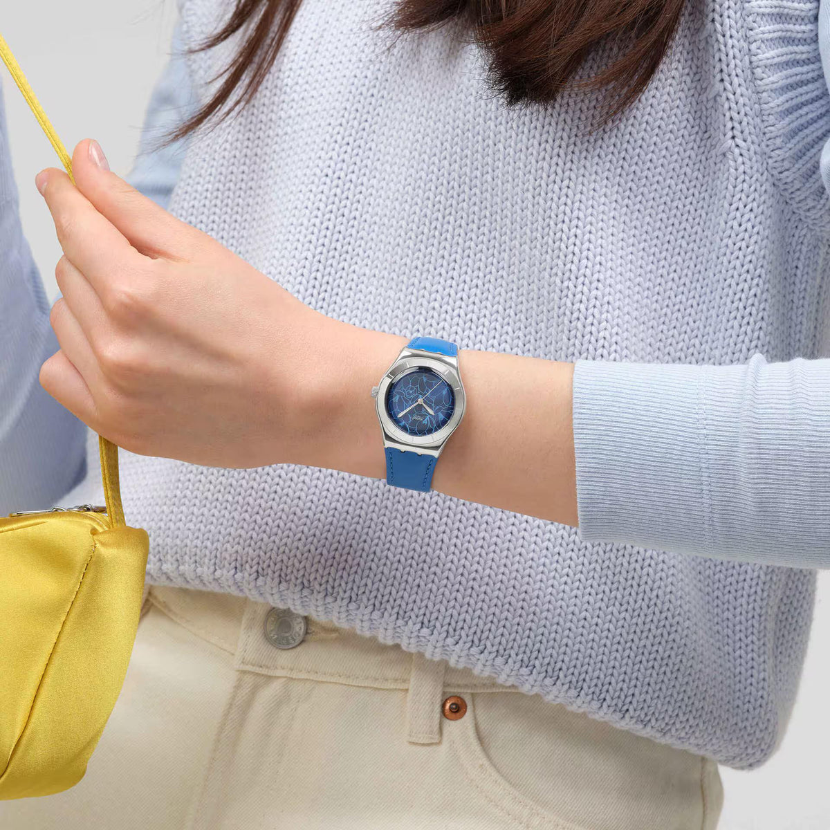 Blue leather strap watch on wrist, blue floral dial with silver-tone case