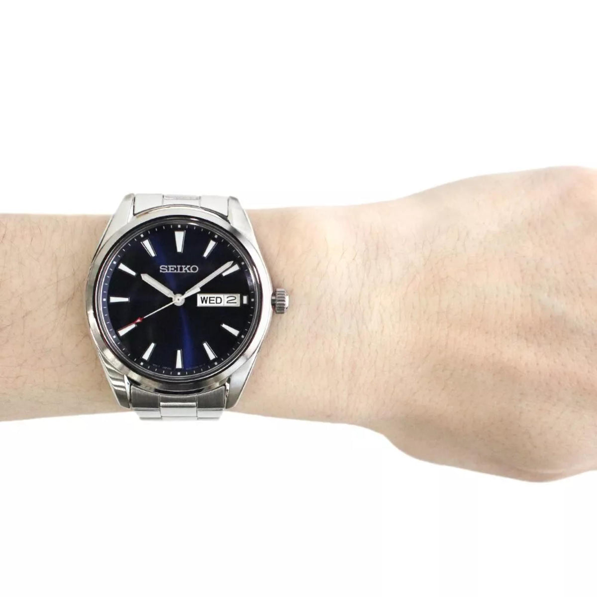 Stainless steel men's watch with blue dial on wrist, metal bracelet and crown