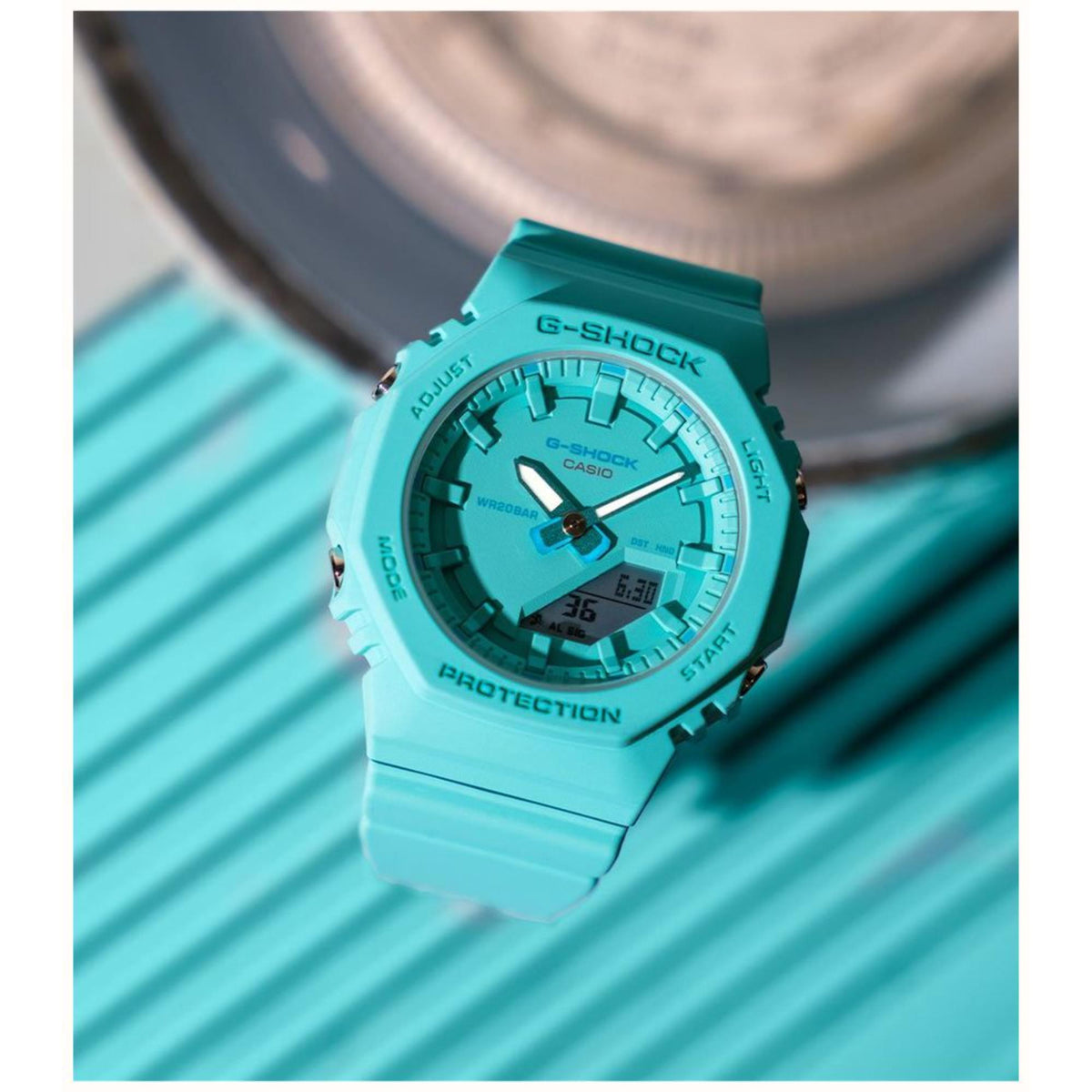 Turquoise resin sport watch with green dial, analog hands, and digital time readout.