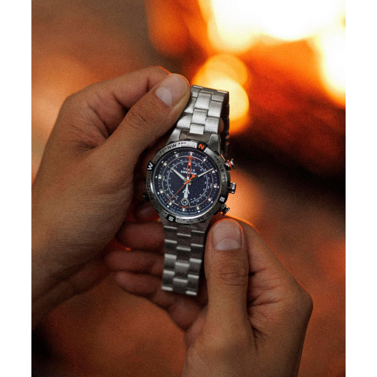Men's steel quartz watch on wrist with dark blue dial and metal bracelet links