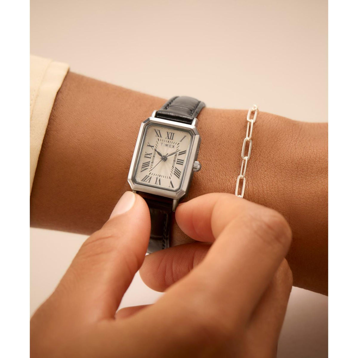 Women's Timex quartz watch on wrist with black leather strap and white Roman numeral dial