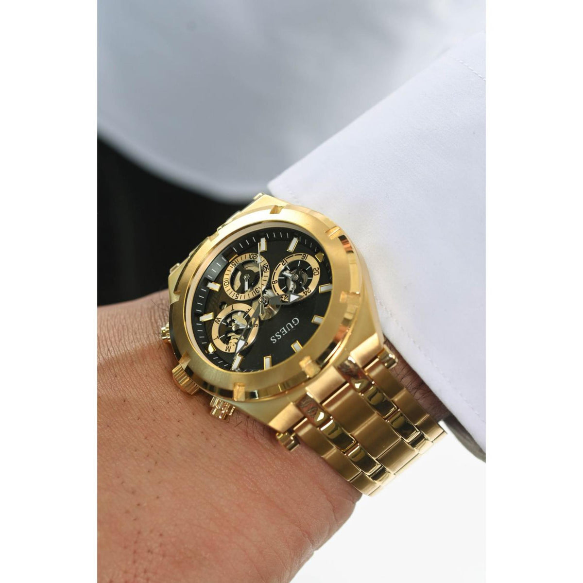 Men's gold-tone chronograph watch on wrist with black dial and silver subdials
