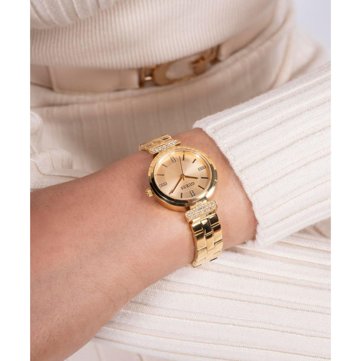Women’s gold-tone watch with champagne dial and crystal bezel on wrist