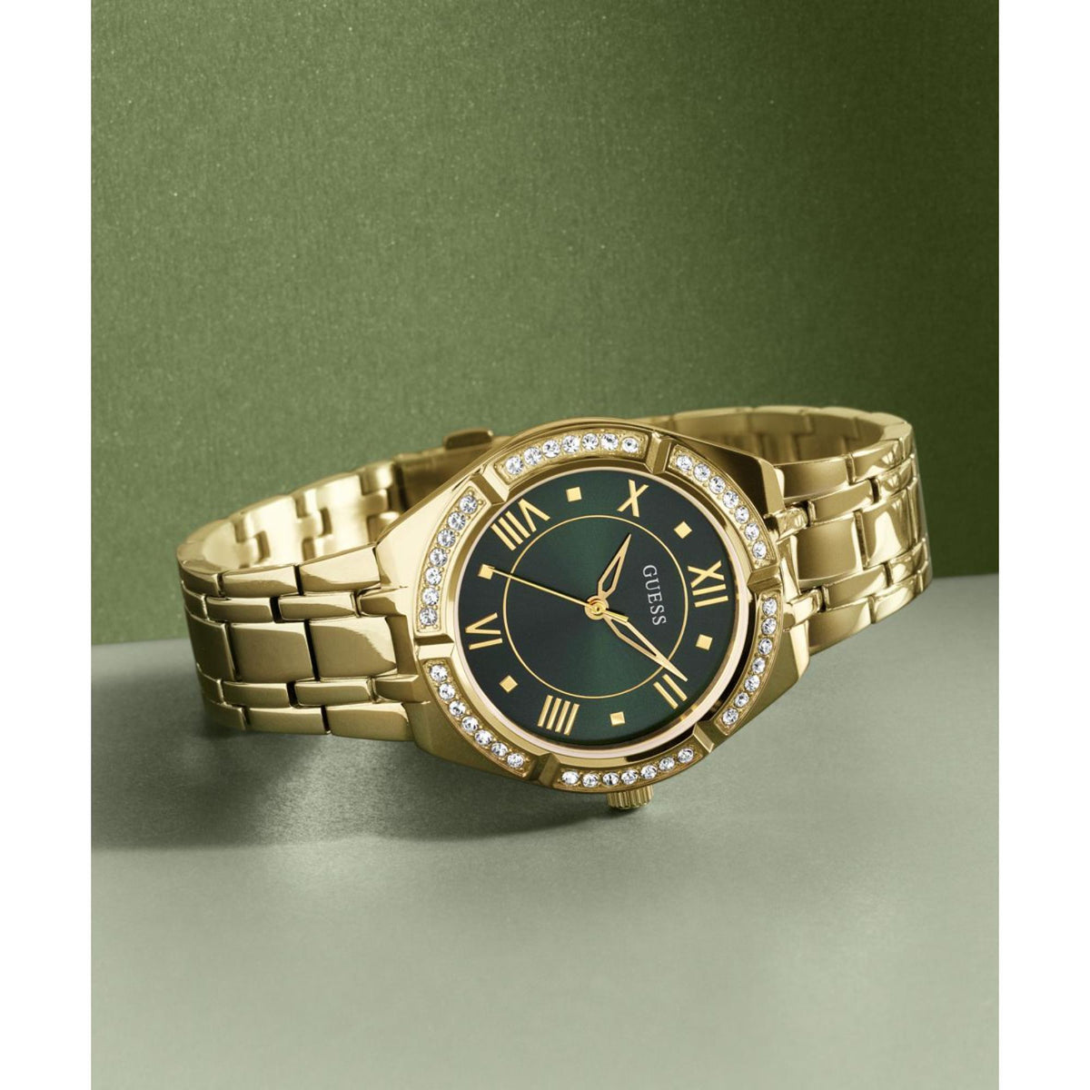 Gold-tone women's watch on wrist with green dial and crystal-studded bezel