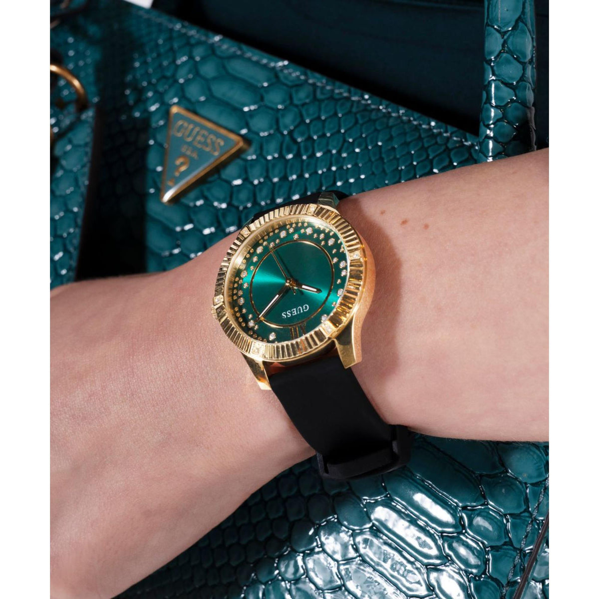 Guess women's watch close-up, green dial with gold-tone bezel and black silicone strap