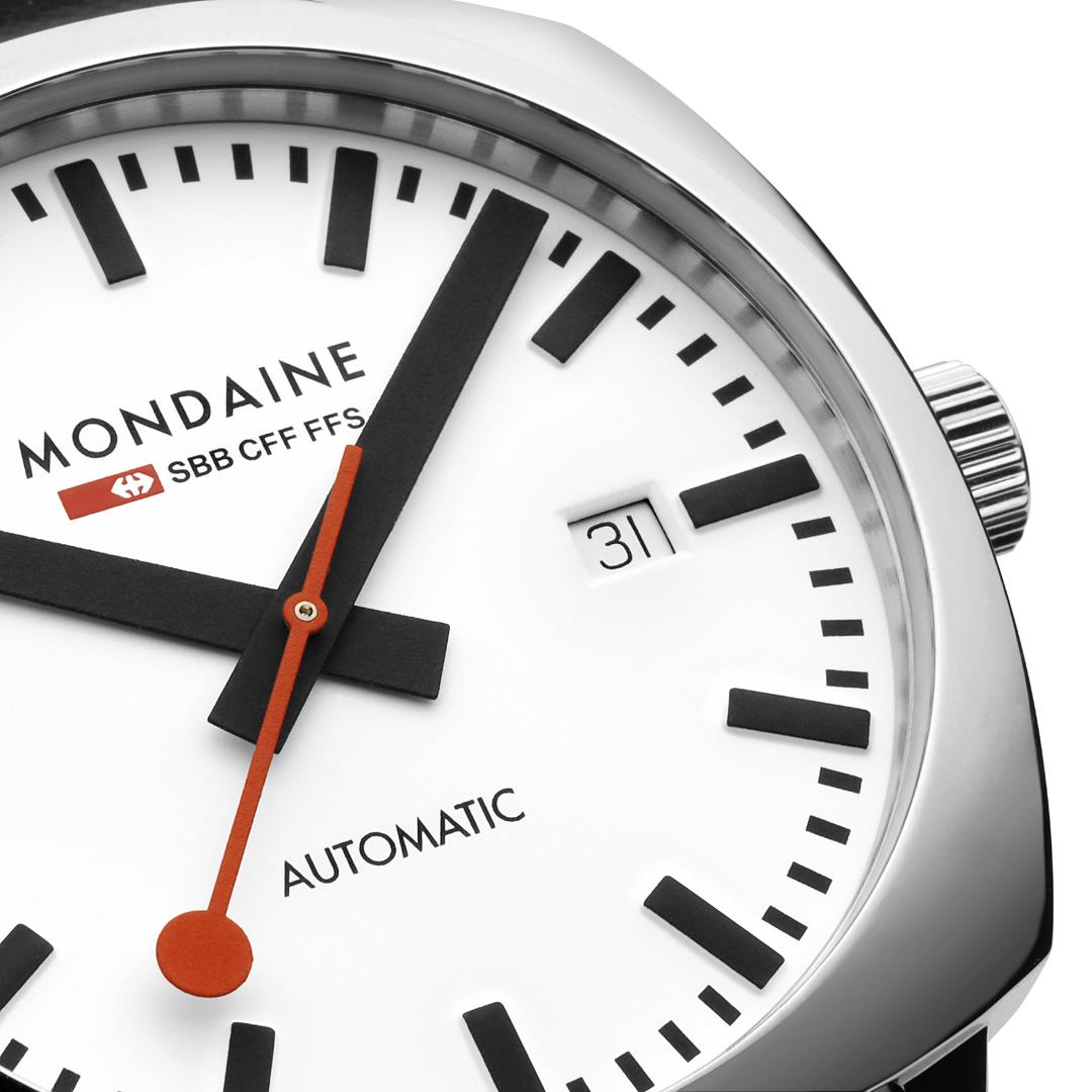 Close-up Mondaine Cushion watch dial with black markers, date window, orange seconds hand