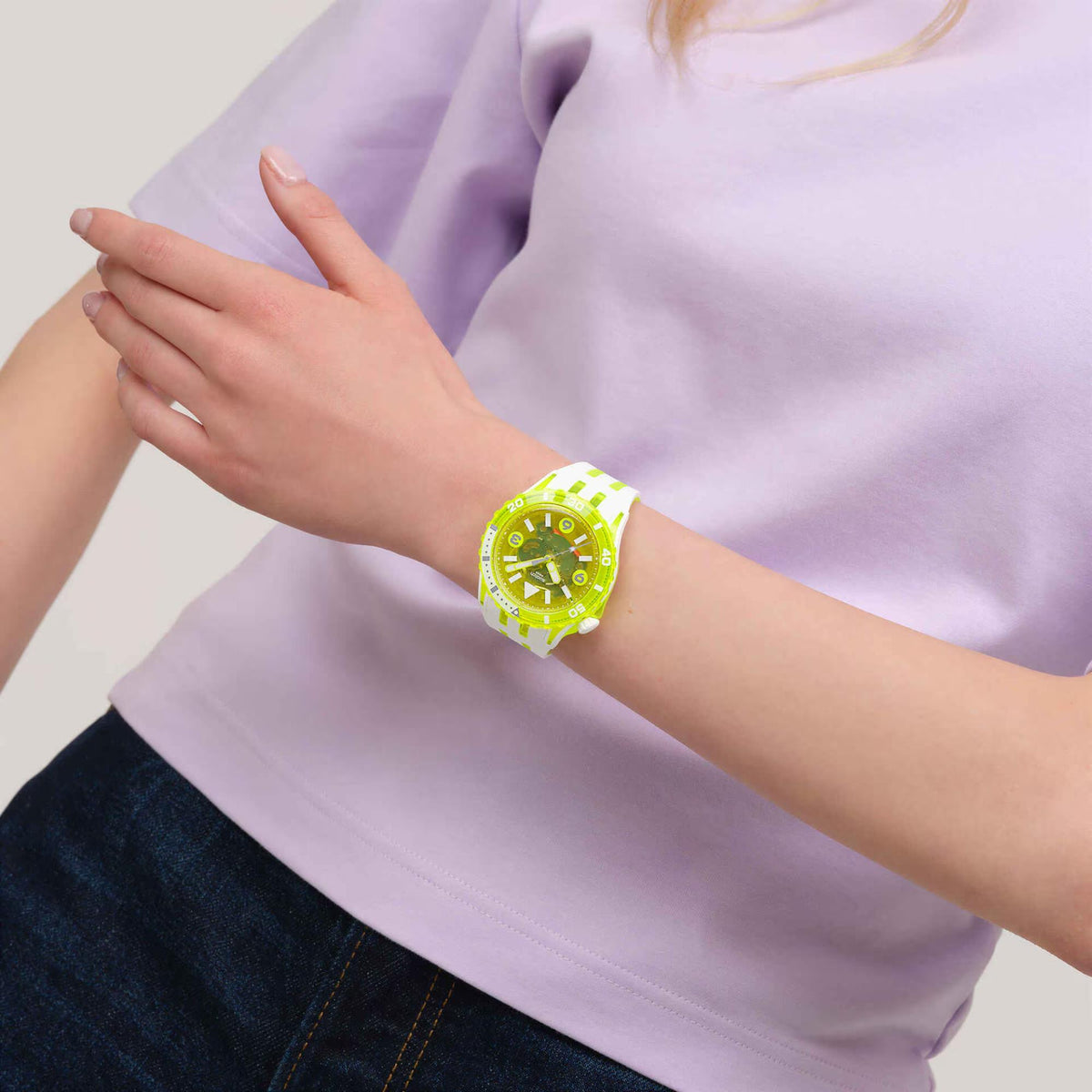 Swatch watch on wrist, bright green dial and white silicone strap with neon green details