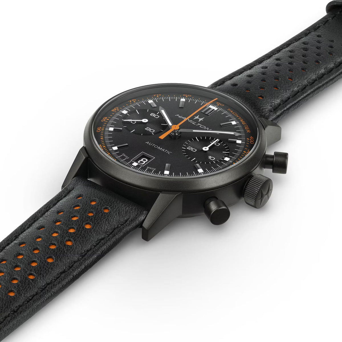 Black chronograph watch with perforated leather strap, tachymeter bezel and subdials