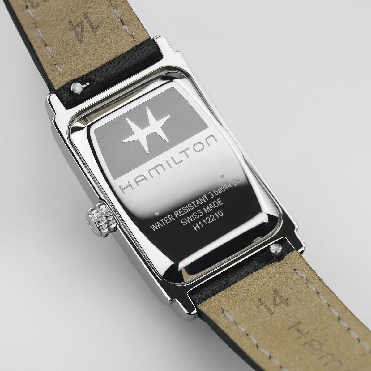 Ladies quartz watch caseback view with silver hardware and black leather strap.