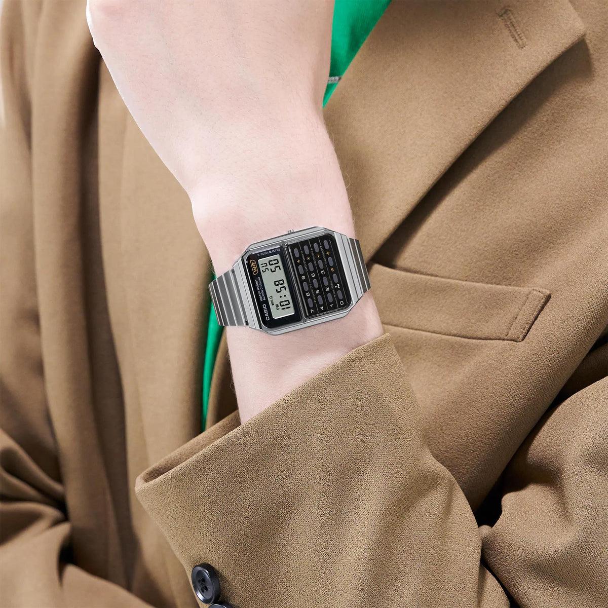 Casio calculator-style digital watch on wrist with silver metal bracelet