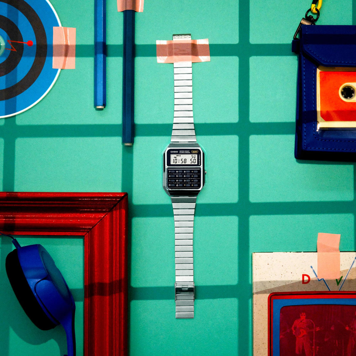 Calculator-style Casio digital watch with silver metal bracelet, standing upright