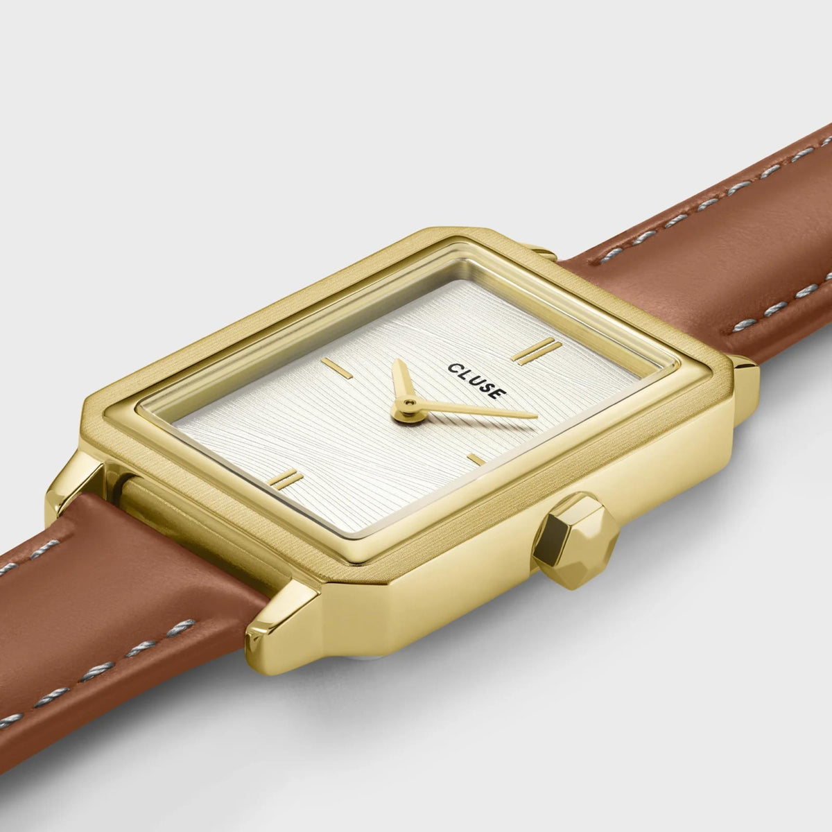 Women's gold square watch with white textured dial and brown leather strap, angled