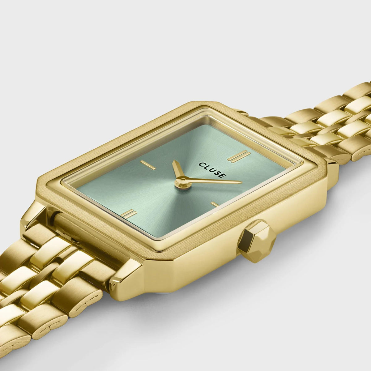 Gold-tone rectangular watch with green dial and metal link bracelet, angled view