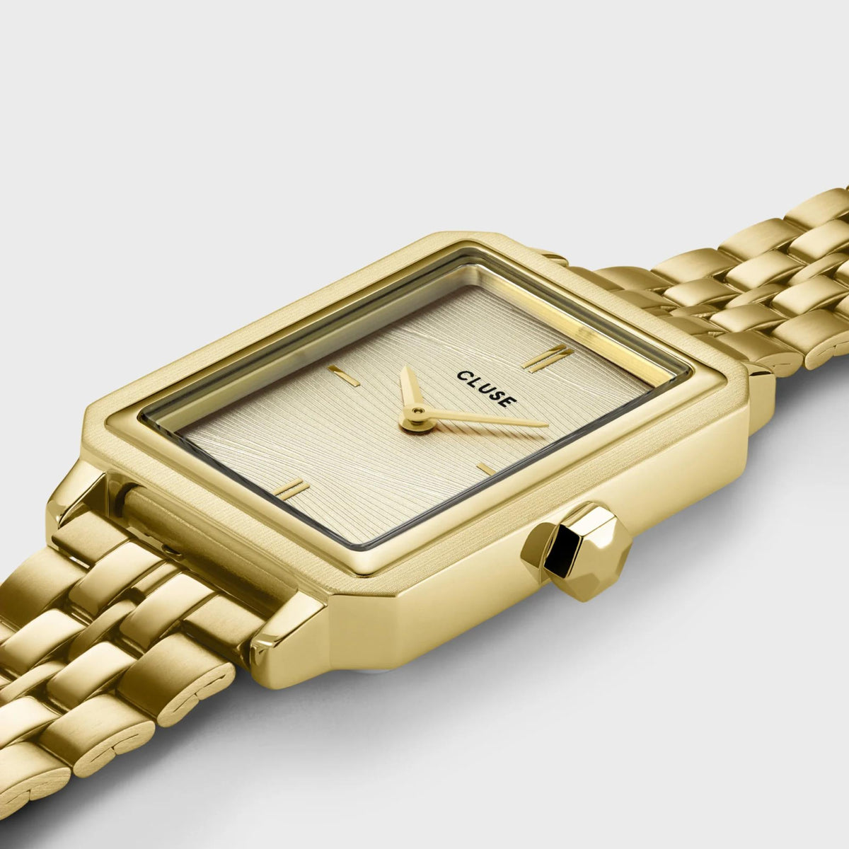 Gold-tone square-faced women’s wristwatch with light dial and braided metal link strap