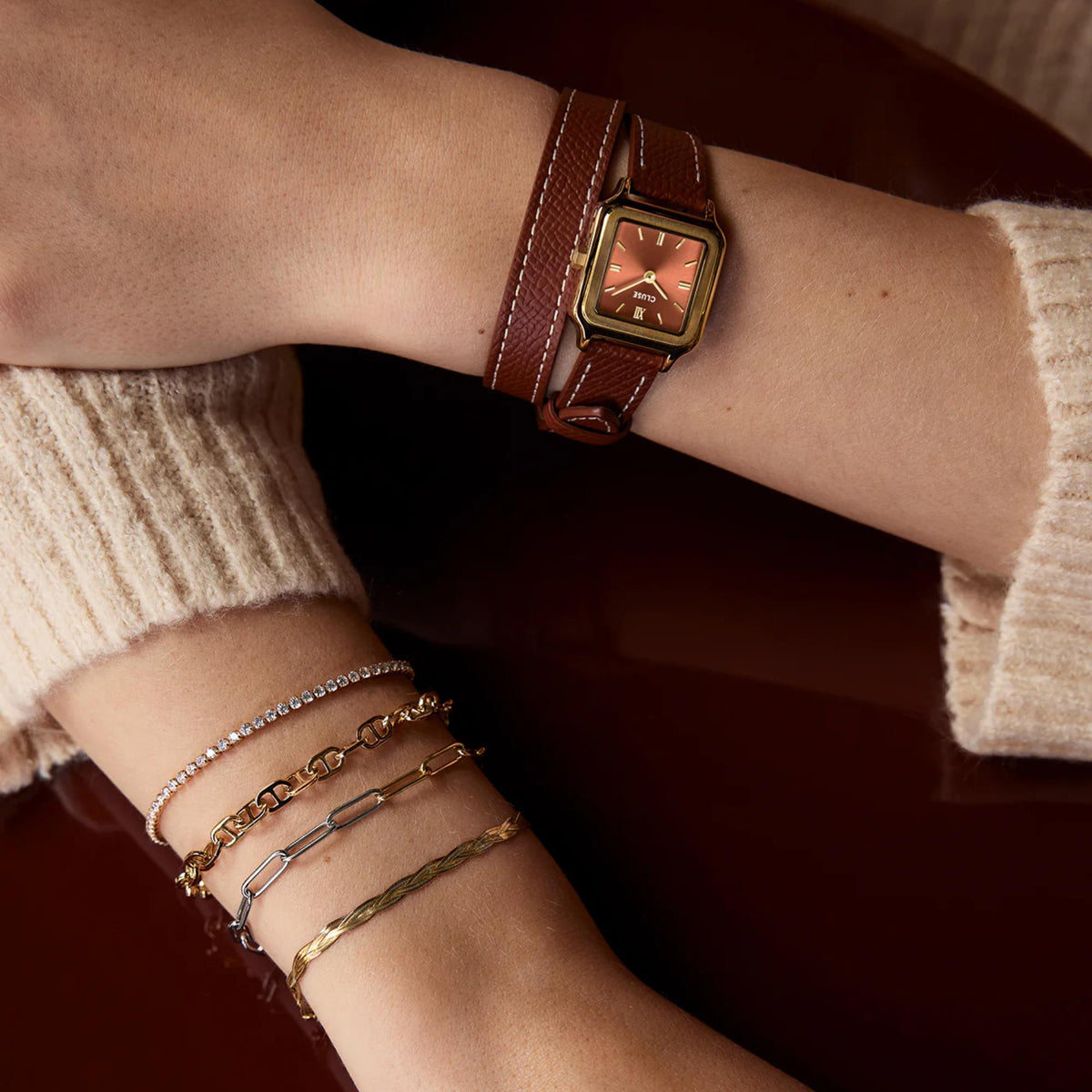Brown leather strap square watch close-up with gold case and red-brown dial