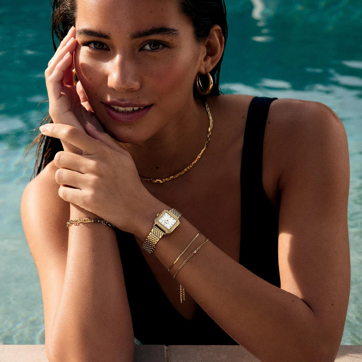 CLUSE women’s square quartz watch with gold-tone band and white dial on arm