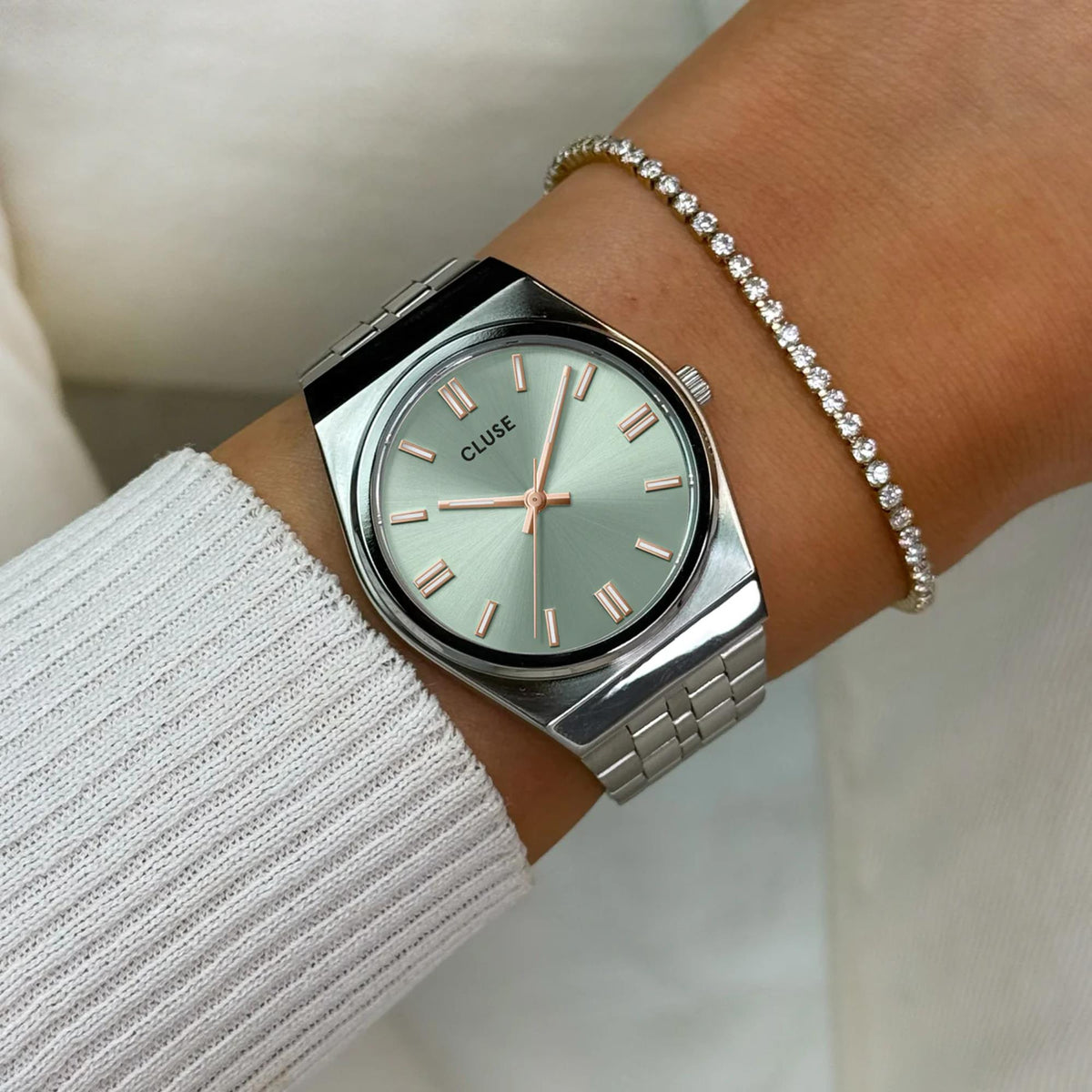 Women’s stainless steel watch on wrist with mint-green dial, rose gold indices, and bezel