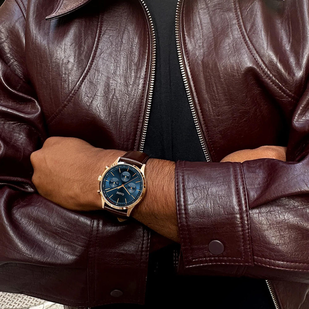 Men's chronograph watch with blue dial and brown leather strap on wrist