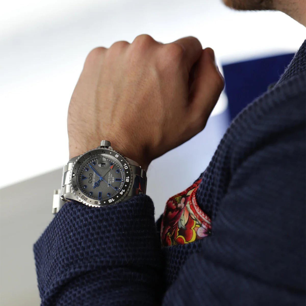 Men's stainless steel GMT watch with blue dial and fabric strap, wrist view