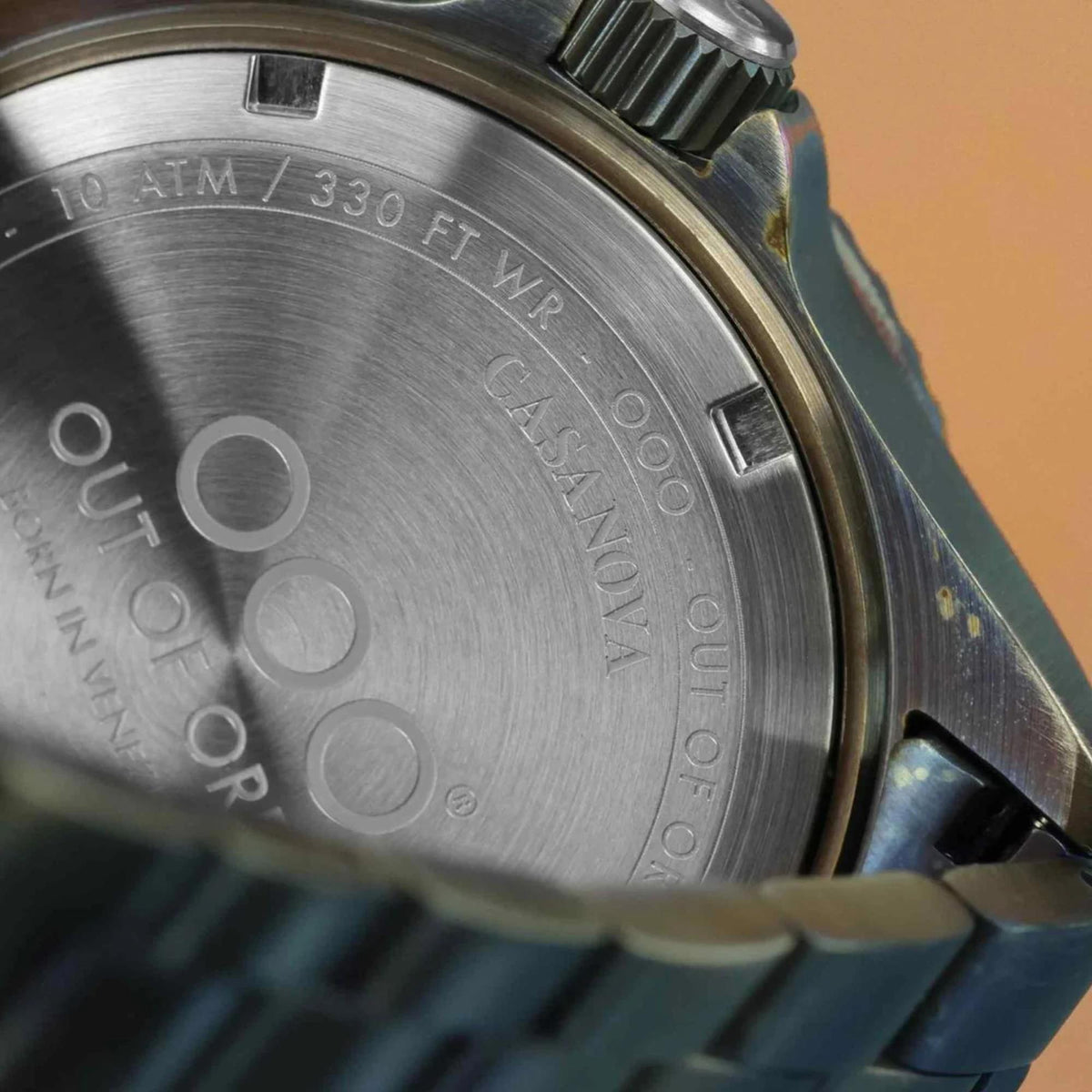 Stainless watch caseback engraved 10 ATM / 330 FT, screws, and model text