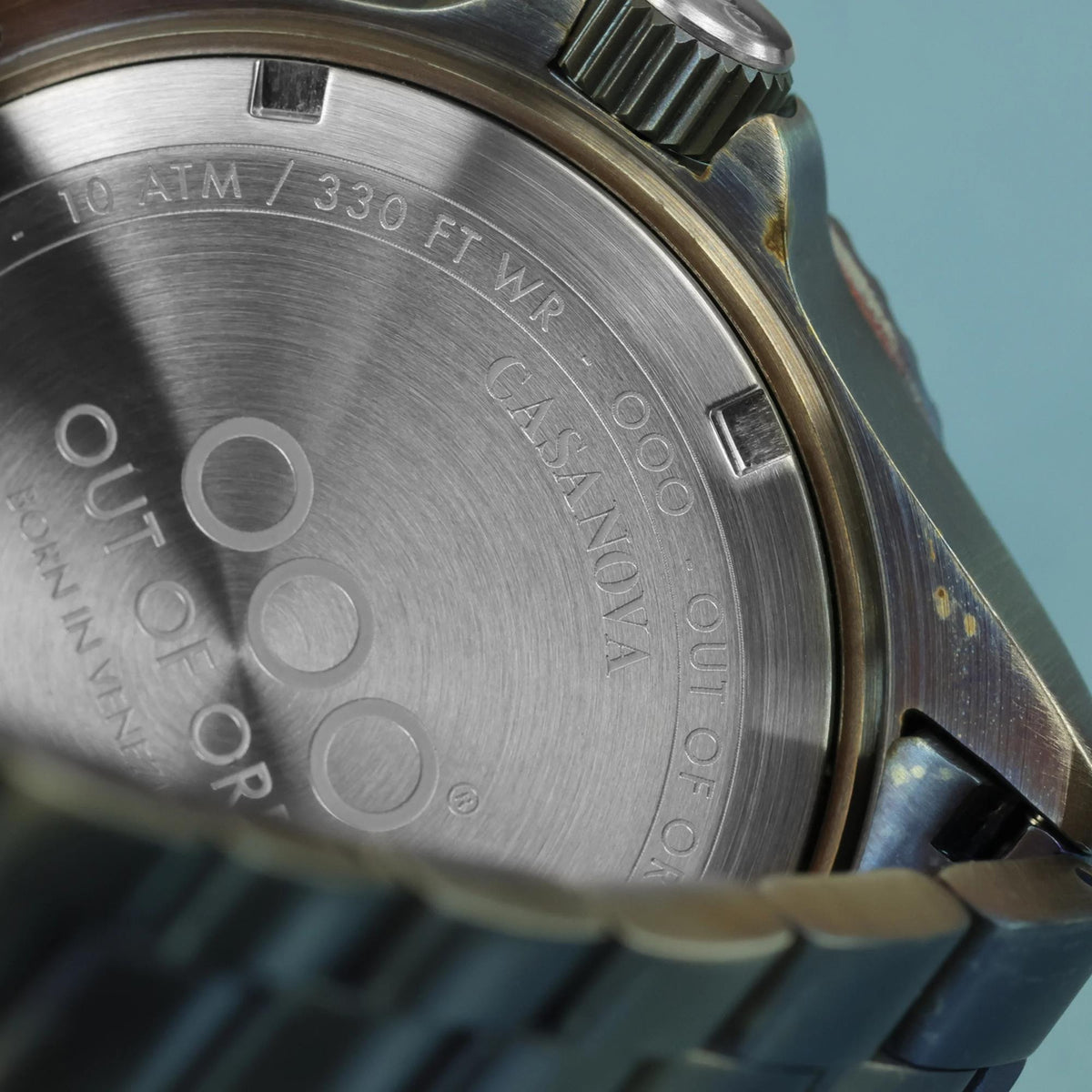 Back of men's quartz watch with engraved case details and metal strap