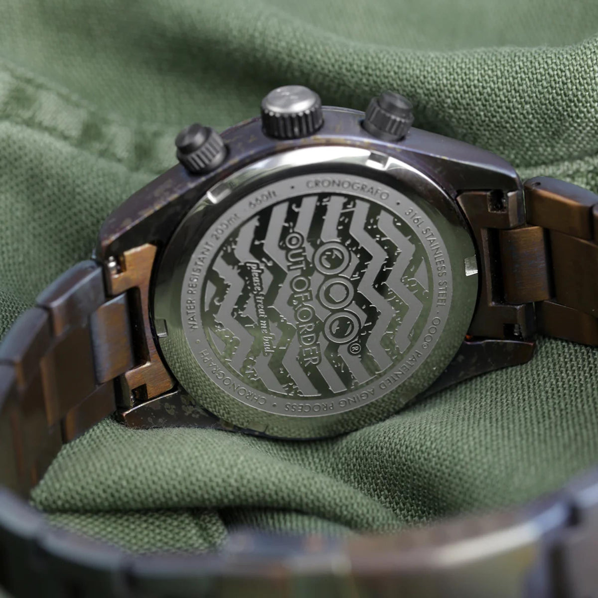 Men's sporty watch caseback with engraved pattern on green fabric