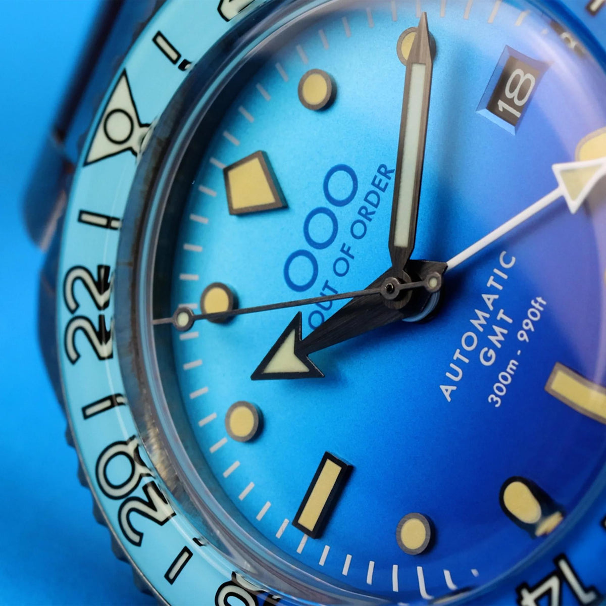 Close-up of men's automatic watch with blue dial, gold indices, and black minute hands