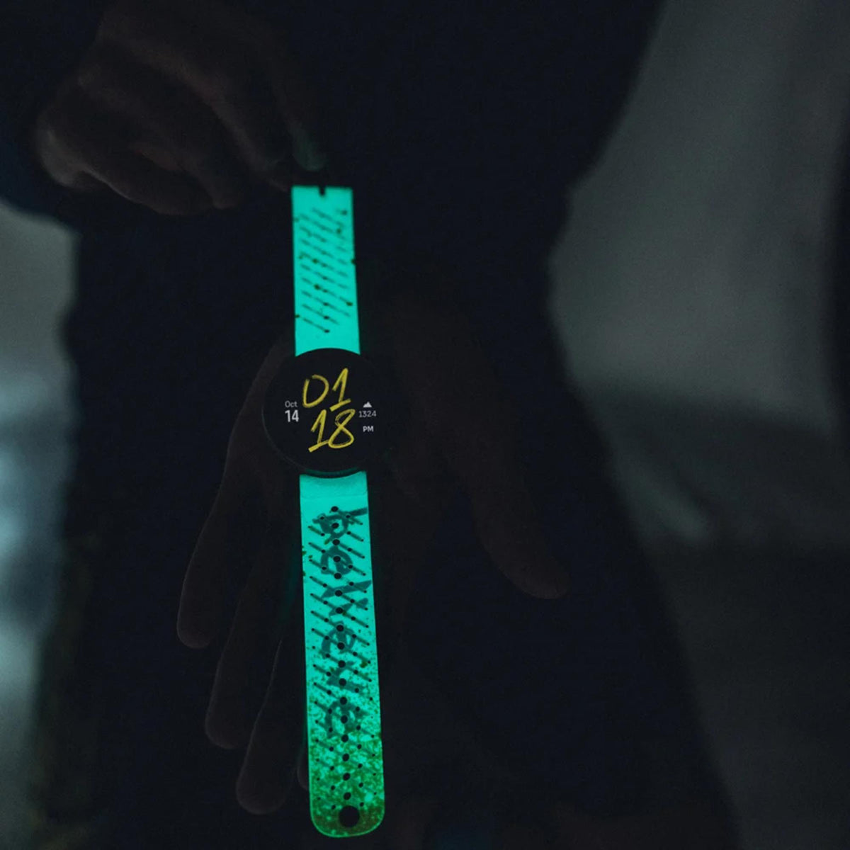 Neon silicone watch strap with teal ends and lime speckled pattern.