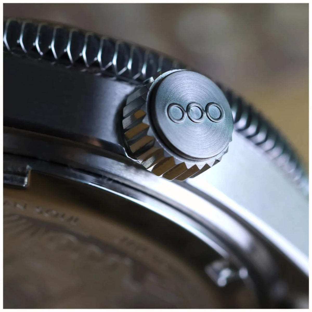 Close-up of automatic steel watch crown and textured bezel edge