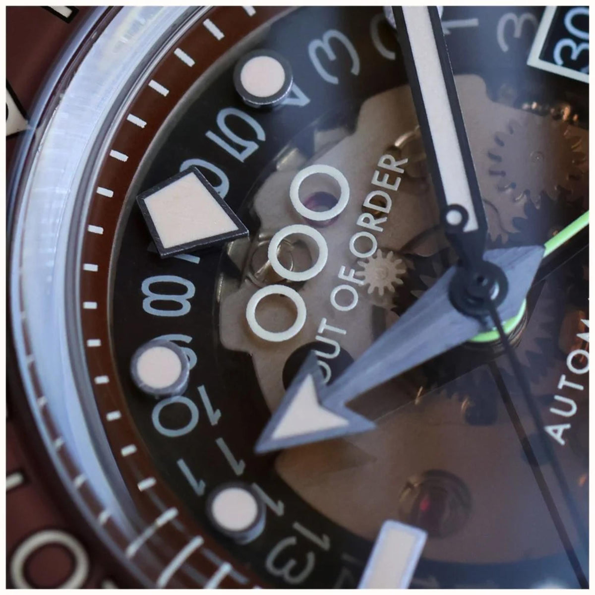 Close-up of watch dial with bold indices, 00 and 10 marks, and automatic text