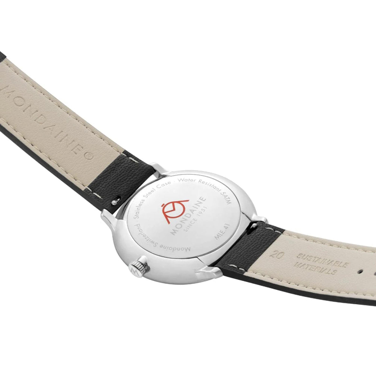 Close-up of the Mondaine Doppio watch's polished silver stainless steel caseback, showing engraved details, water resistance specs, and the cream-colored interior lining of the black strap