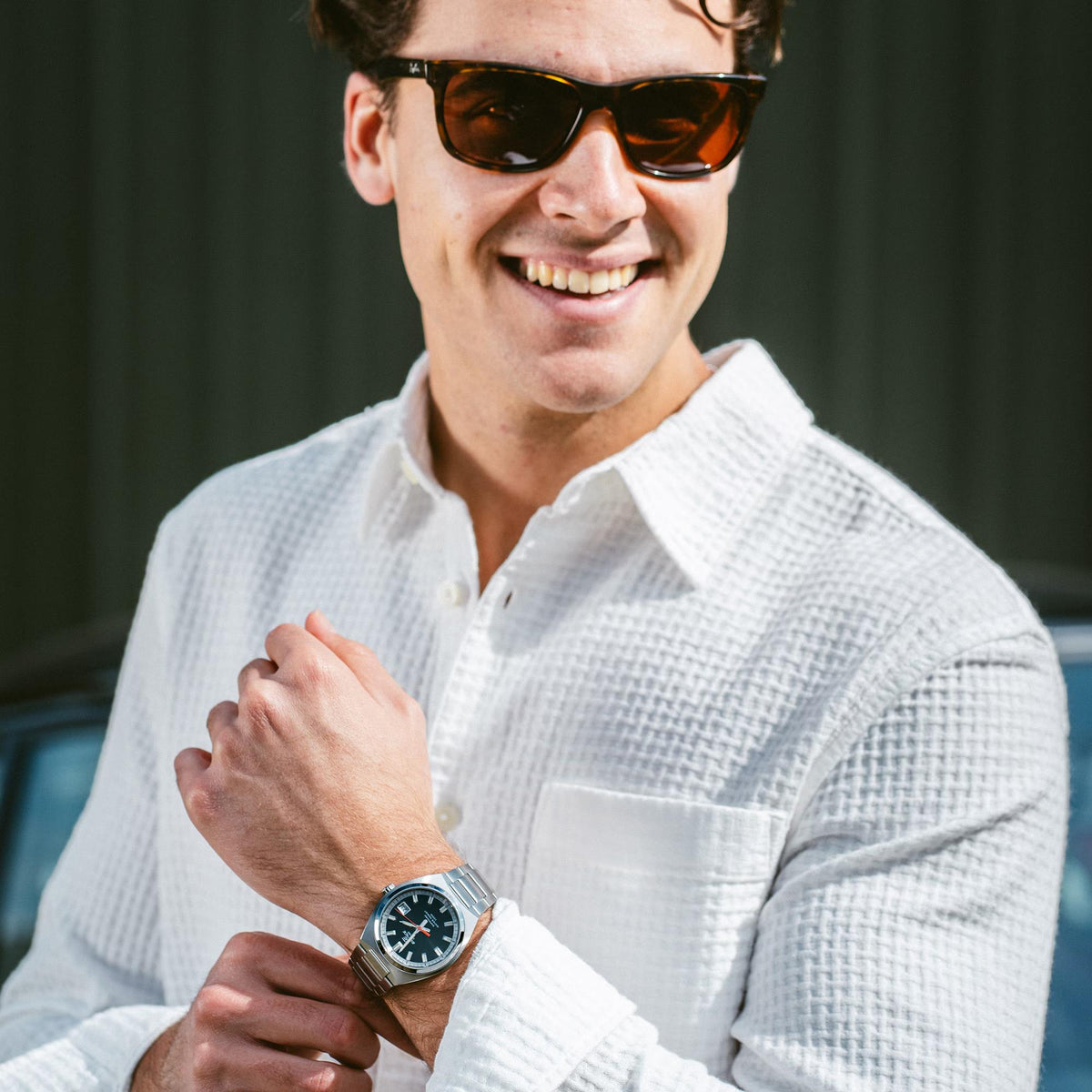 Model wearing sunglasses and a white shirt posing with the Casio Edifice EFB-109D-1AVEF steel watch visible on the wrist