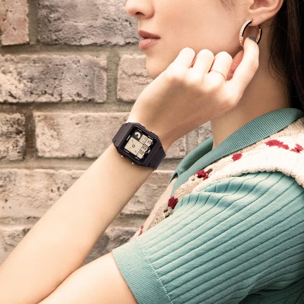 Black resin strap digital watch worn on wrist with LCD time display