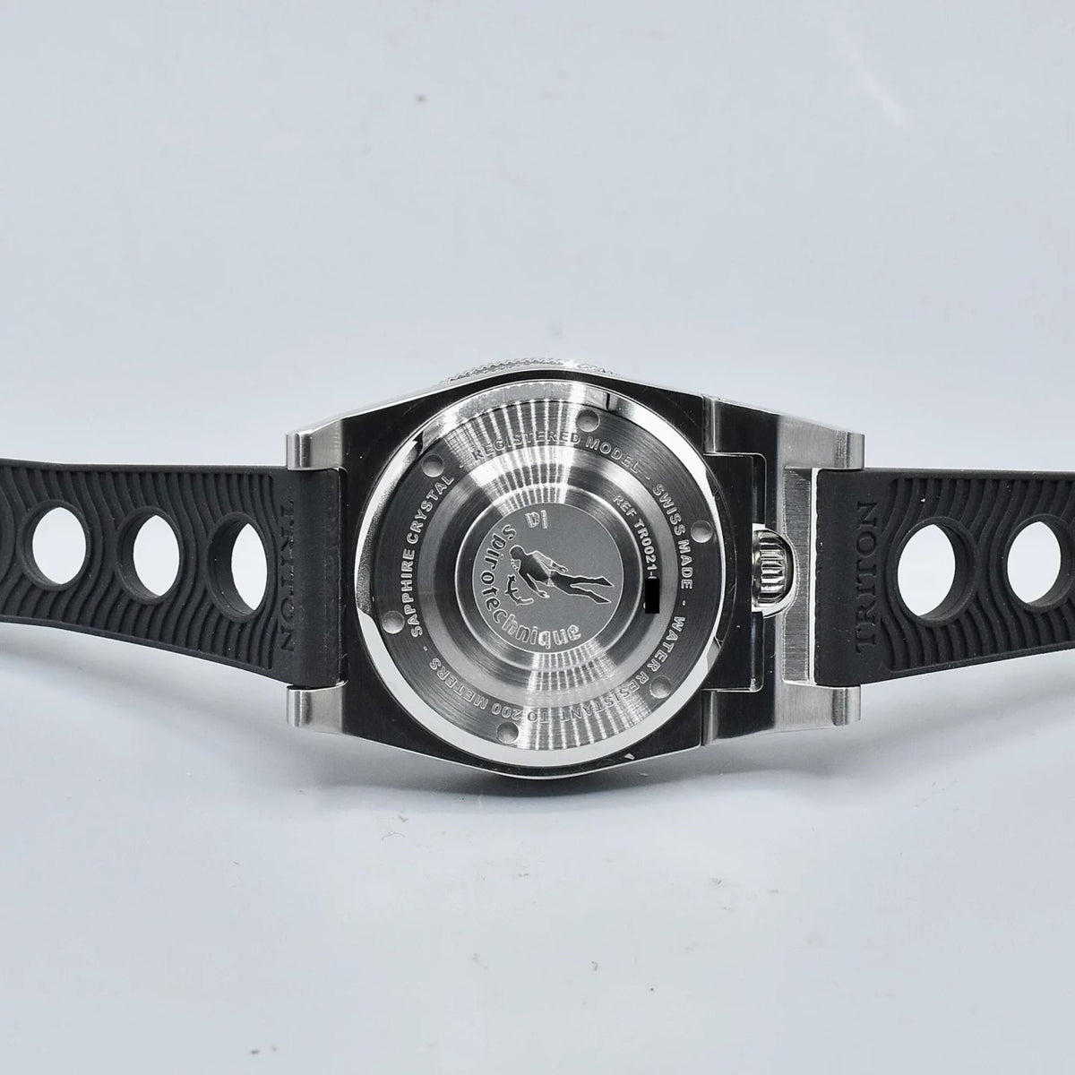 Men's dive watch caseback with black rubber strap and silver spiro-style dial