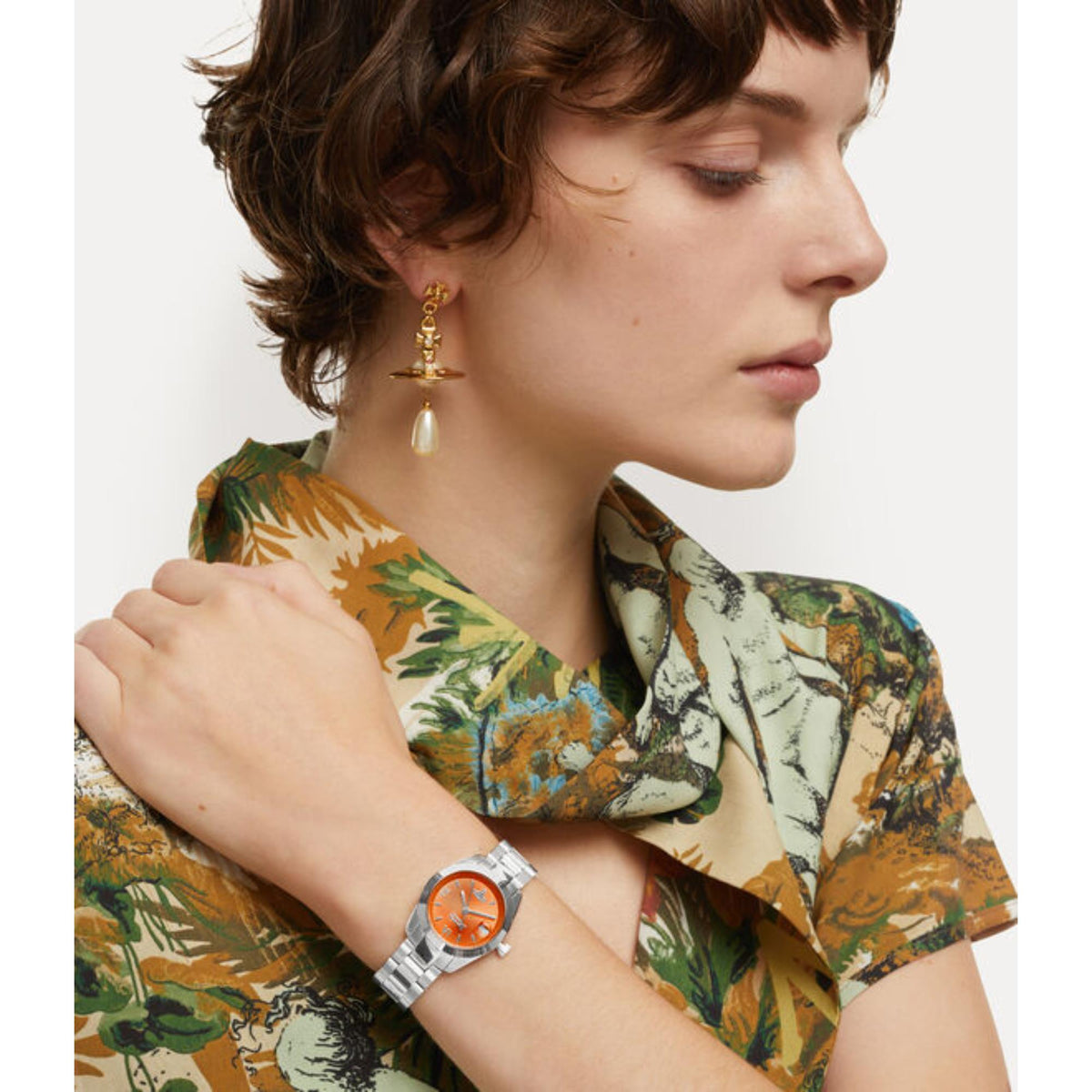 Women’s stainless steel watch with orange dial on wrist