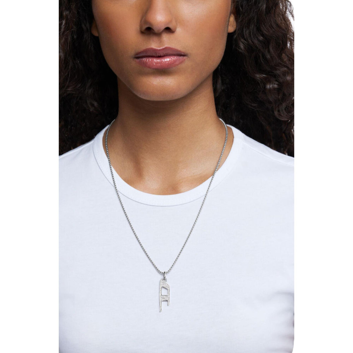 Stainless steel pendant necklace with letter F charm worn on a model’s neck