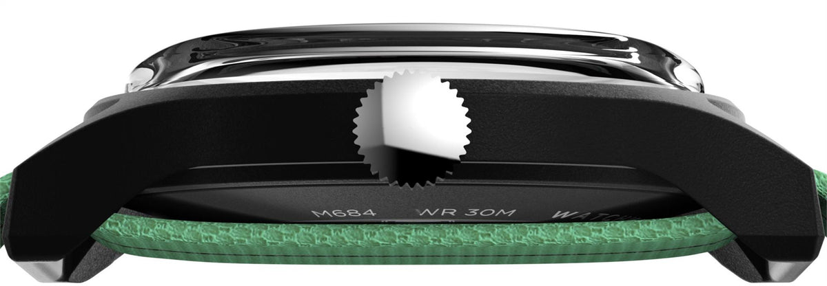 Black watch case top view with crown, green strap edge visible, textured case detailing