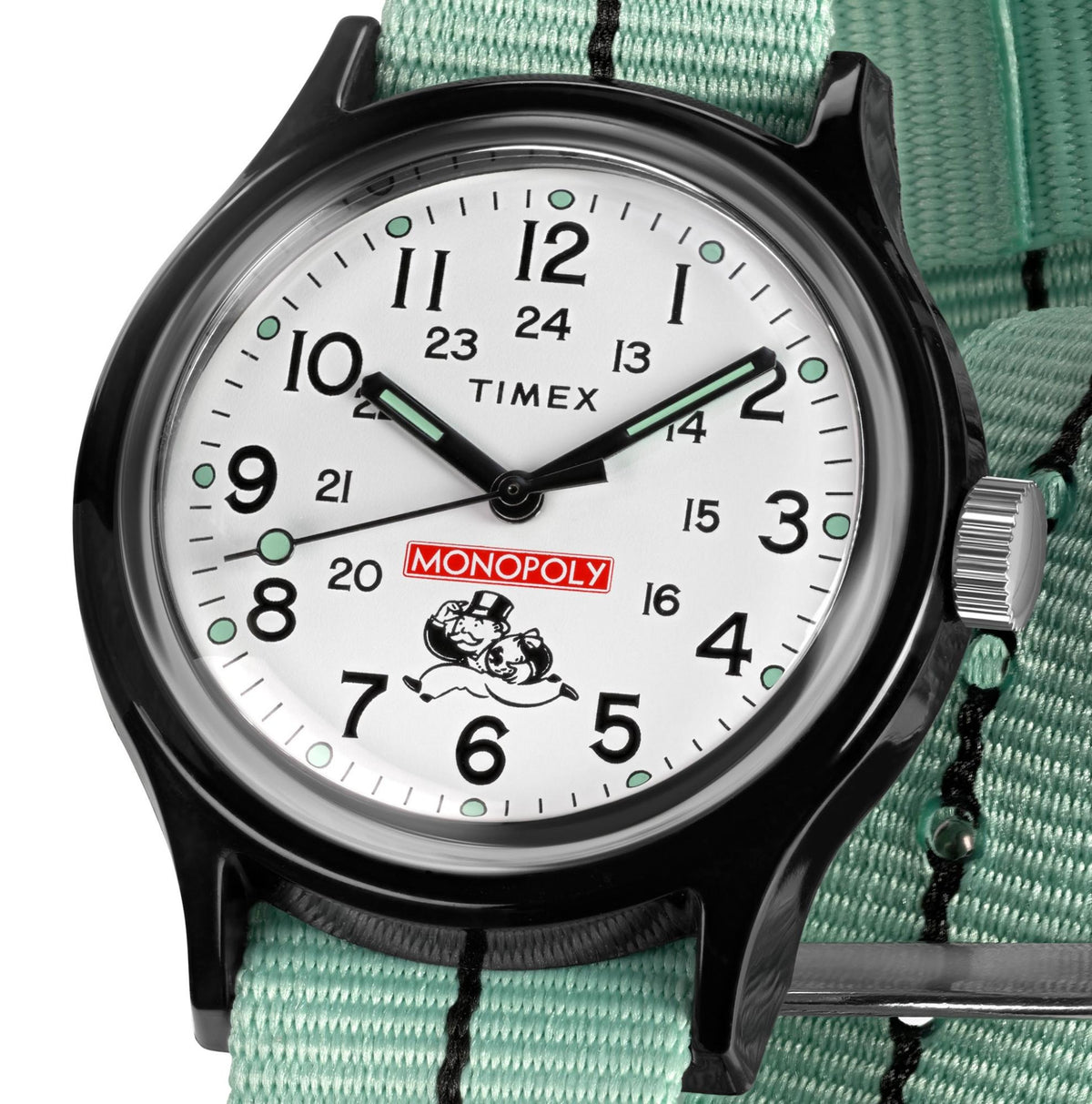 Close-up of white watch dial with green accents and black hands; Monopoly logo on center