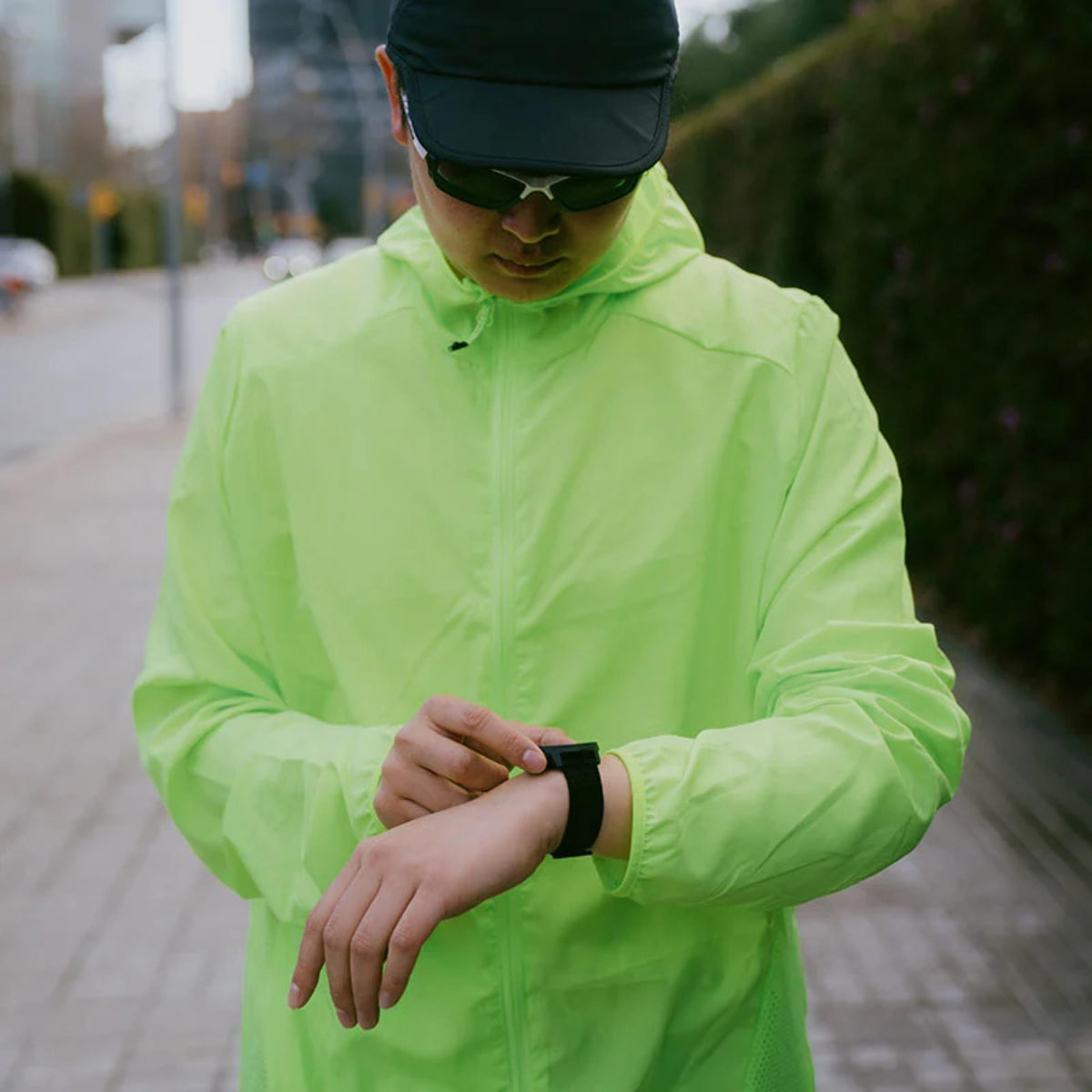 Suunto Athletic 7 Loop SS051131000 black textile watch strap lifestyle view worn on wrist by runner in high-visibility jacket