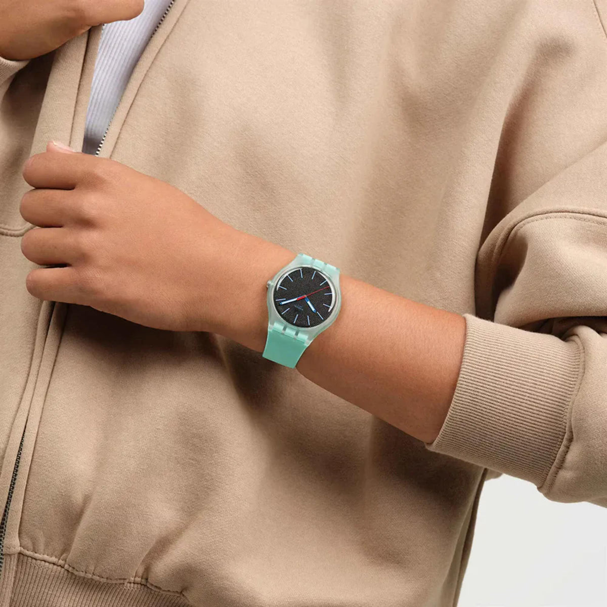 Teal silicone strap watch with black dial worn on an arm