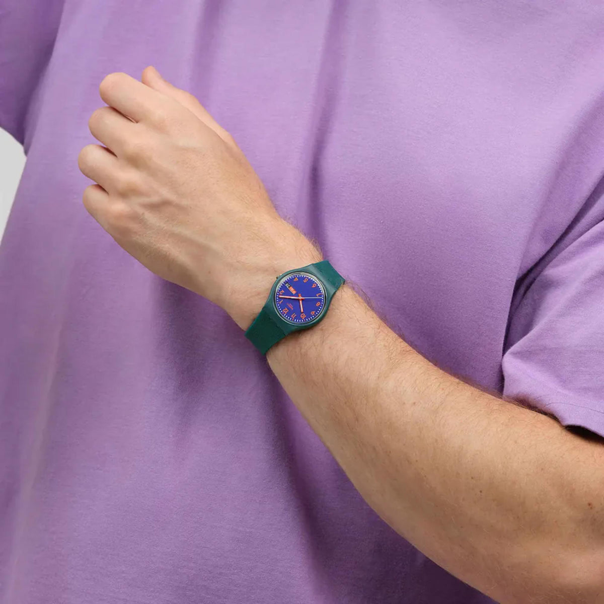 Swatch watch with blue dial and silicone strap, worn on forearm