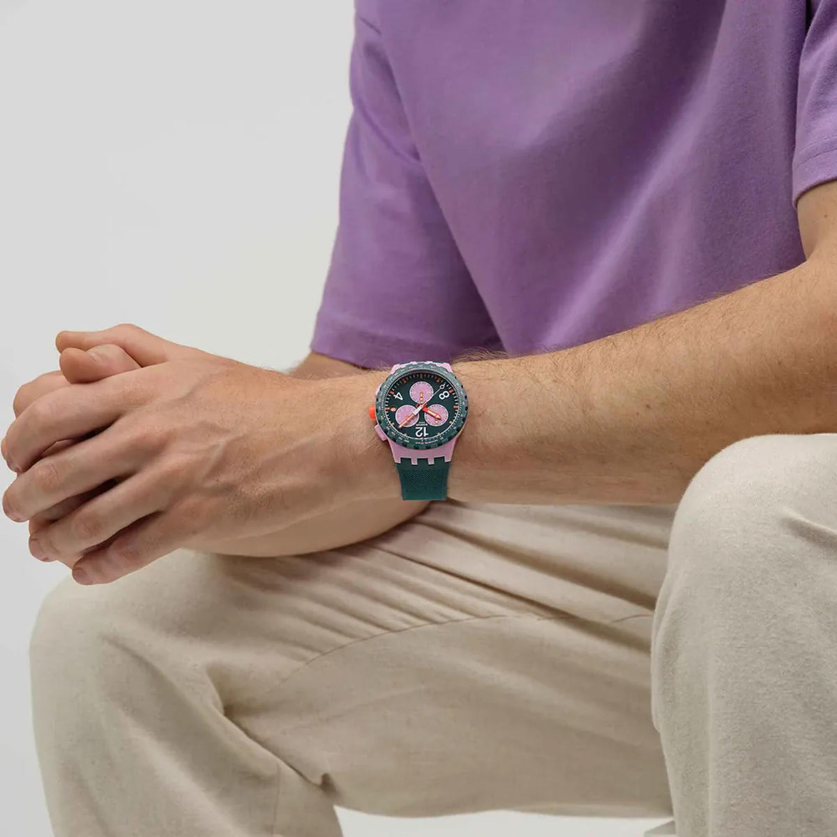 Swatch chronograph watch with green silicone strap on forearm