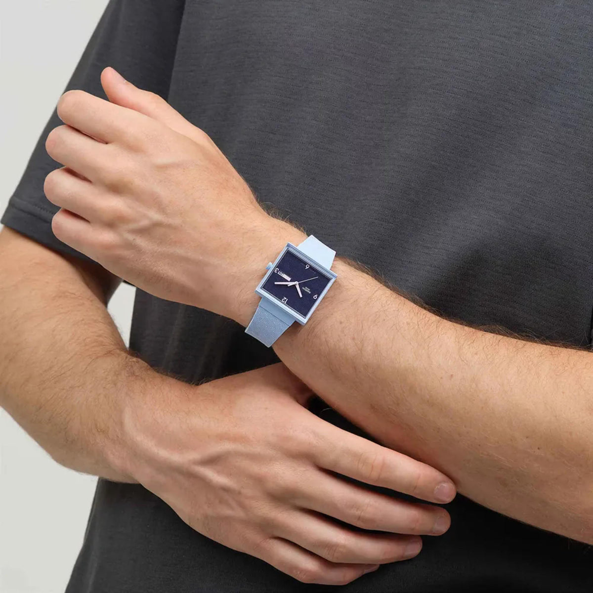Close-up of square quartz watch with blue dial and light blue silicone strap