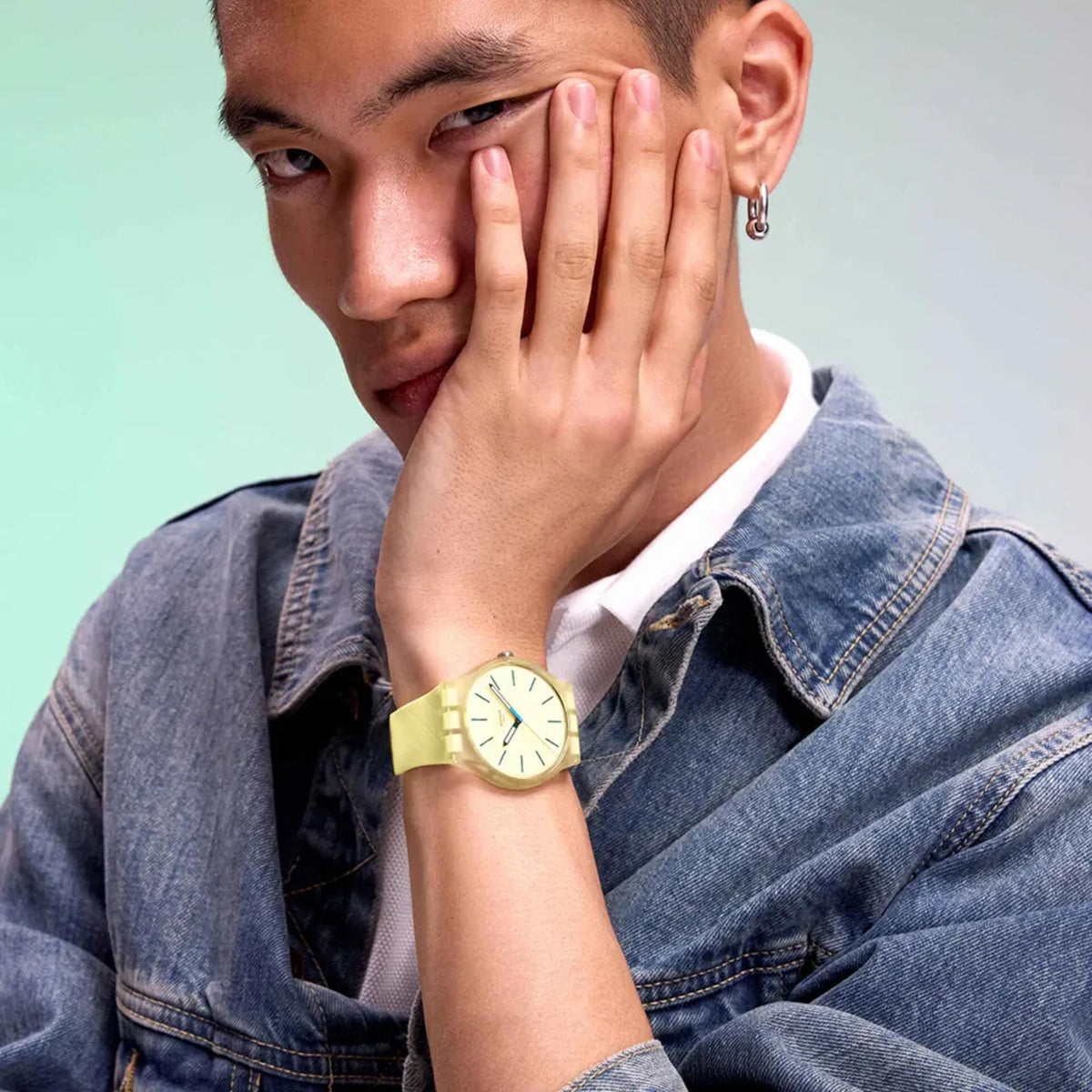 Yellow silicone strap quartz watch on wrist, light yellow dial with teal hour markers