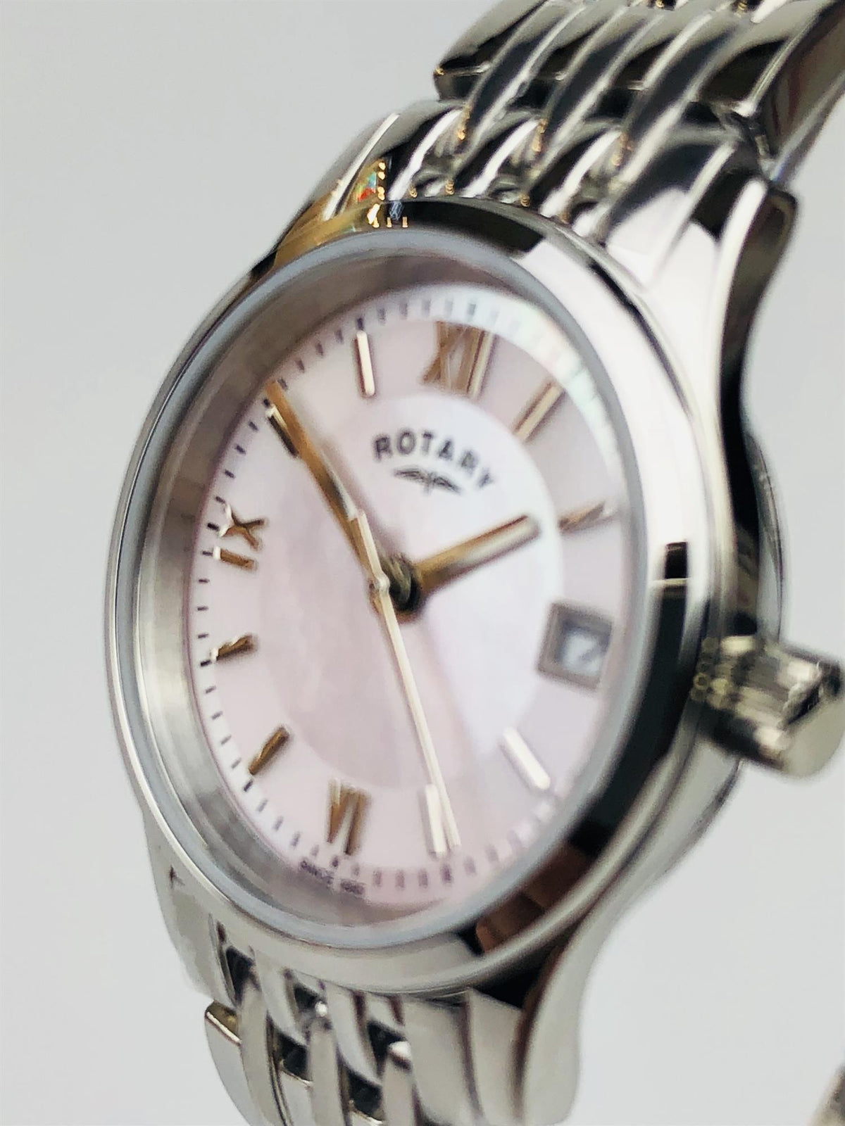 Angled view of stainless steel watch with mother-of-pearl dial and Roman numerals