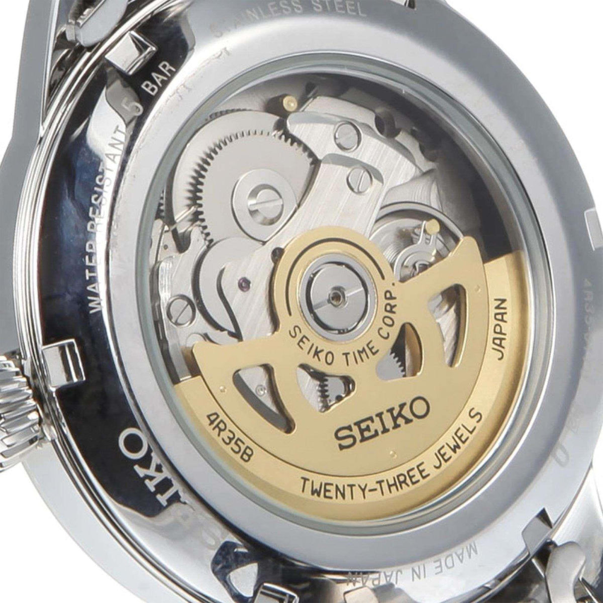 Close-up of Seiko automatic caseback with gold-toned movement and stainless steel rim